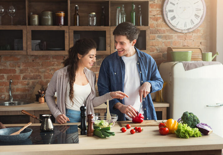 Photo of young couple in kitchen prepping healthy meal.